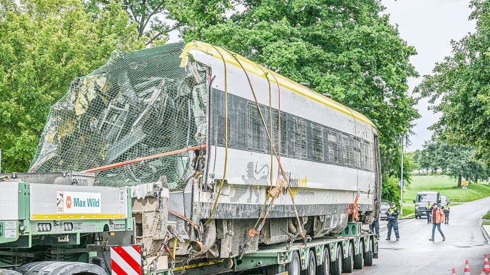 Ein verladener Zug Wagon steht an der Unfallstelle, an der ein Regionalzug entgleist ist. Ein Regionalexpress war am Sonntagabend (27.07.2025) in Riedlingen nach bisherigen Erkenntnissen infolge eines Hangrutsches entgleist. Foto: Jason Tschepljakow/dpa