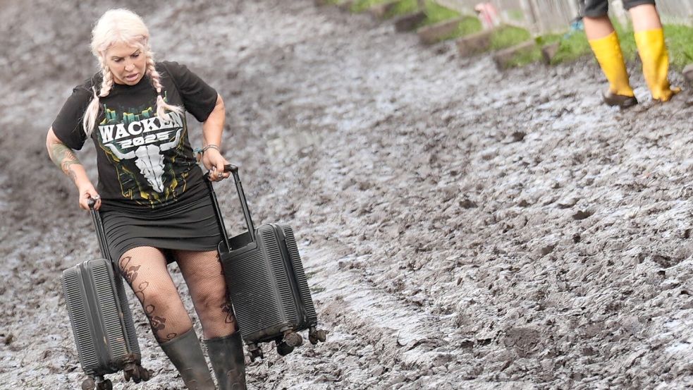 Nicht alle Besucherinnen und Besucher sind auf den Schlamm vorbereitet. Foto: Marcus Brandt/dpa