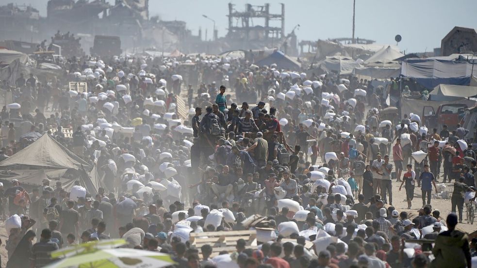 Palästinenser tragen Säcke mit Mehl aus einem Hilfskonvoi. (Archivbild) Foto: Jehad Alshrafi/AP/dpa