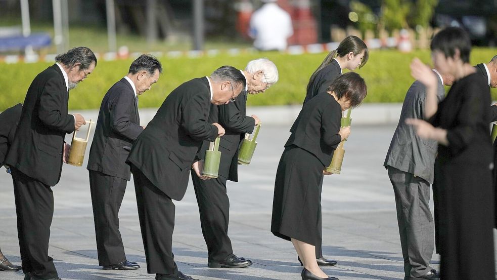 Teilnehmer der Gedenkveranstaltung in Hiroshima halten eine Schweigeminute ab. Foto: Louise Delmotte/AP/dpa