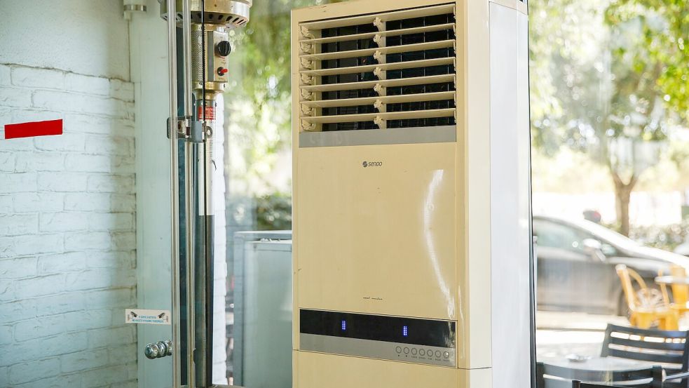 Athen: Eine mobile Klimaanlage steht im verglasten Innenraum eines Cafés. (Archivbild) Foto: Socrates Baltagiannis/dpa