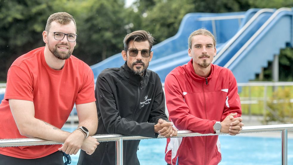 Lars Ostendorp (von links), Betriebsleiter Björn Molter und Henri Frank haben sich fürs Foto im Freibad Borssum aufgestellt. Die Saison dort sei bislang „insgesamt zufriedenstellend“, so Molter. Foto: Klaus Ortgies