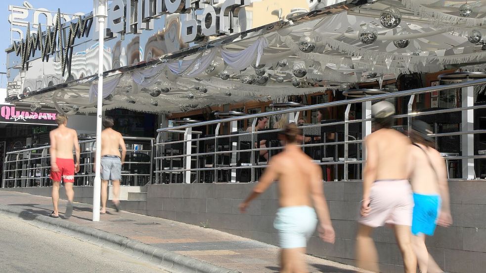 Junge Männer gehen mit nacktem Oberkörper auf Mallorca spazieren. (Archivbild) Foto: Clara Margais/dpa