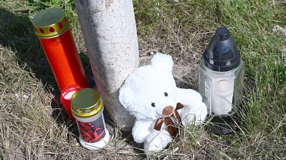 Menschen haben Kerzen und einen Teddybären an der Unfallstelle abgestellt. Foto: Bernd Weißbrod/dpa