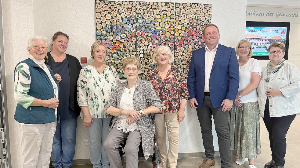 Ein Kunstwerk, an dem viele Friedeburger mit kleinen, individuell gestalteten Holzscheiben beteiligt sind, überreichten die Kunst- und Kulturkreismitglieder an Bürgermeister Helfried Goetz. Das Foto zeigt (von links): Johanna Bleeker, Julia Stamm, Ilse Weers-Dirks, Annemarie Gellermann, Ruth Thurm, Helfried Goetz, Monika Reuß und Corinna Schumacher. Foto: privat