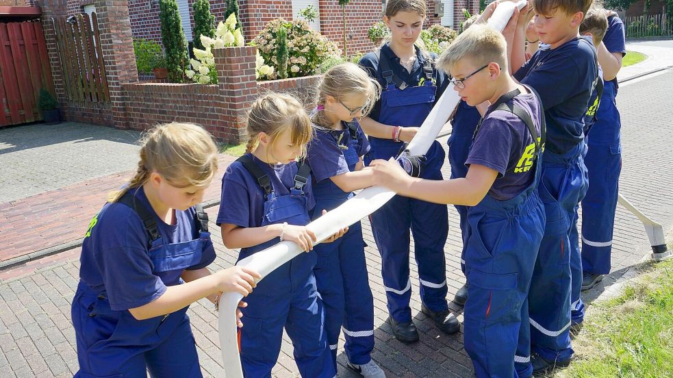 Mit vereinten Kräften und viel Geschick führen diese Mädchen und Jungen einen Ball durch einen Feuerwehrschlauch. Foto: privat