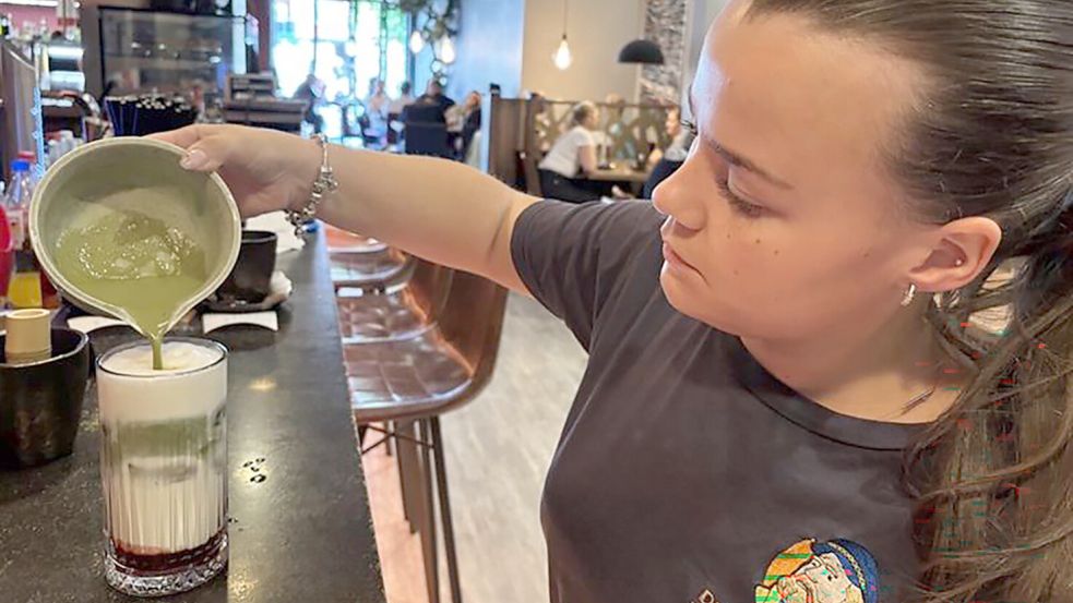 Sara Schildhauer bereitet die Iced-Matcha-Latte mit Erdbeerpüree im Café „Der Ostfriese“ zu. Foto: Stephanie Tomé