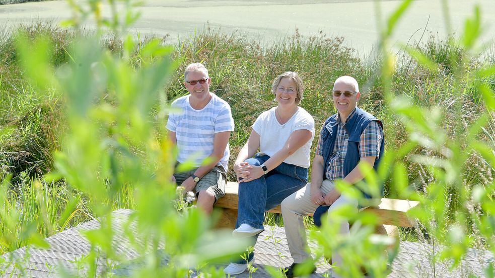 Pastor Ingo Brookmann (von rechts), Kirsten Weers, verantwortliche Mitarbeiterin der Kirchengemeinde, sowie Gerd Otten, der „Kümmerer“ für die Fläche, freuen sich auf die Eröffnung. Foto: Klaus Ortgies