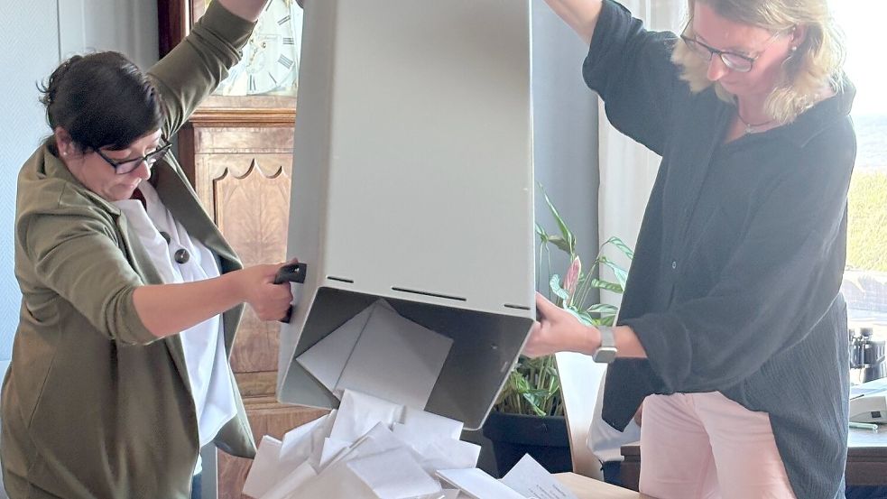 Rieka Beewen (links), Allgemeine Vertreterin des Bürgermeisters, und Wahlleiterin Melanie Scatturin leeren die Stimmzettel aus der Wahlurne auf den Tisch zur Auszählung. Foto: Hanz