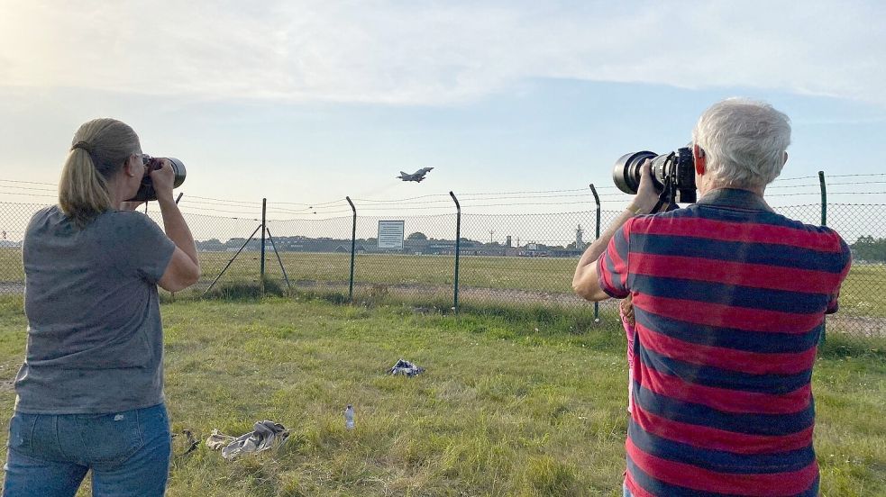 Susanne und Klaus Risthaus fotografieren einen startenden Eurofighter auf dem Flugplatz Wittmundhafen. Sie selbst stehen außerhalb des Zauns. Foto: Imke Oltmanns
