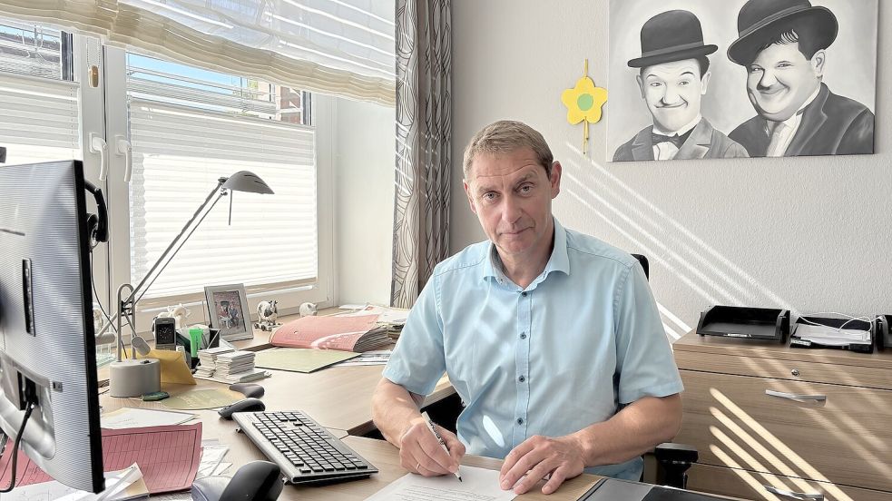 Heinz Trauernicht sitzt an seinem jahrelangen Arbeitsplatz im Rathaus der Gemeinde Uplengen. Foto: Lars Löschen