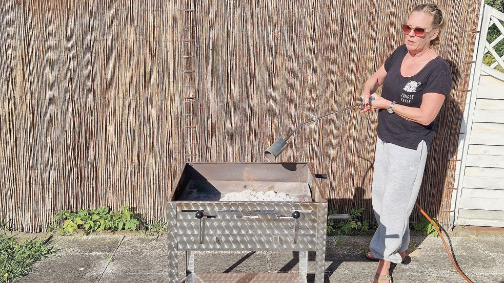 Mit dem Gasbrenner die Grillkohle zum Glühen zu bringen, gelingt in wenigen Minuten. Foto: Tatjana Gettkowski