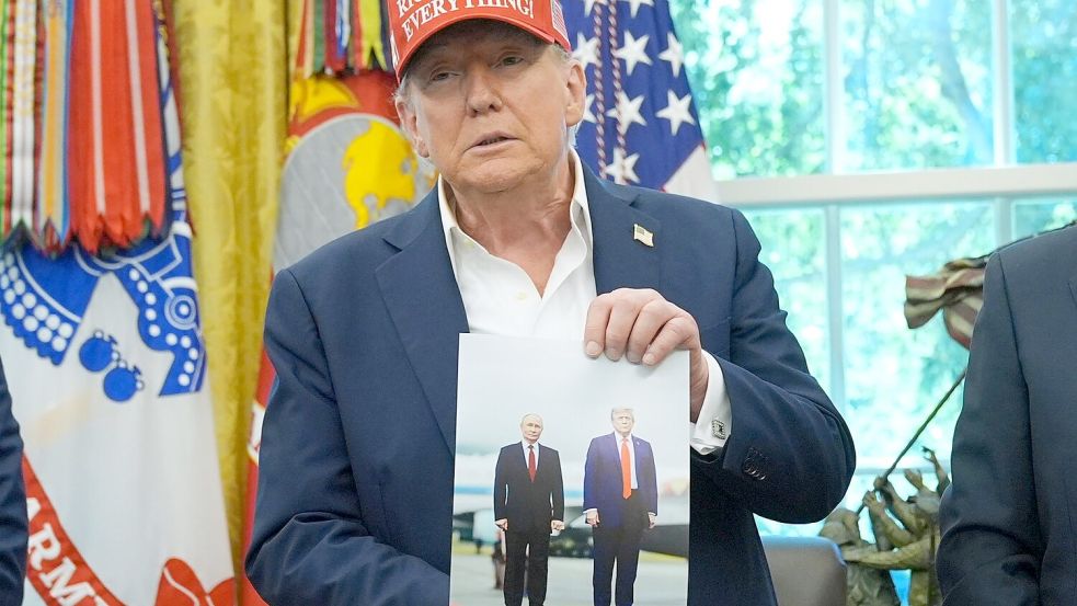 Trump zeigt ein Foto von sich und Putin. Foto: Jacquelyn Martin/AP/dpa