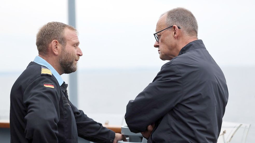 Der Bundeskanzler im Gespräch mit Fregattenkapitän Kübsch. Foto: Jens Büttner/dpa