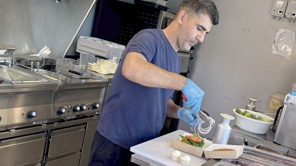 Die Cheeseburger stehen bei den Wittmundern hoch im Kurs, erzählt Sultan Altiner, während er ein Exemplar zum Verzehr zubereitet. Foto: Susanne Ullrich