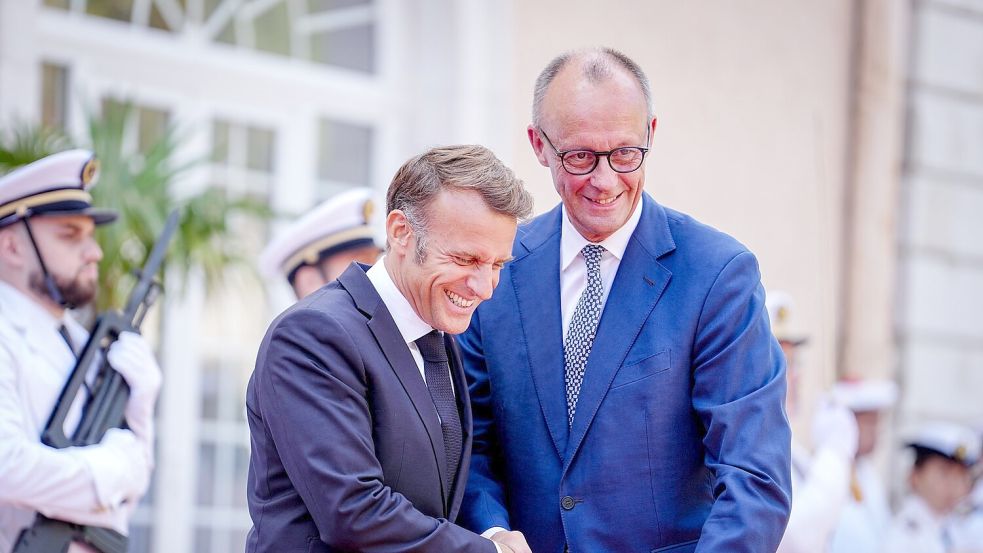 Wie zwei alte Freunde begrüßen sich Macron und Merz vor dem Fort du Cap Brun über der Cote d’Azur. Foto: Kay Nietfeld/dpa