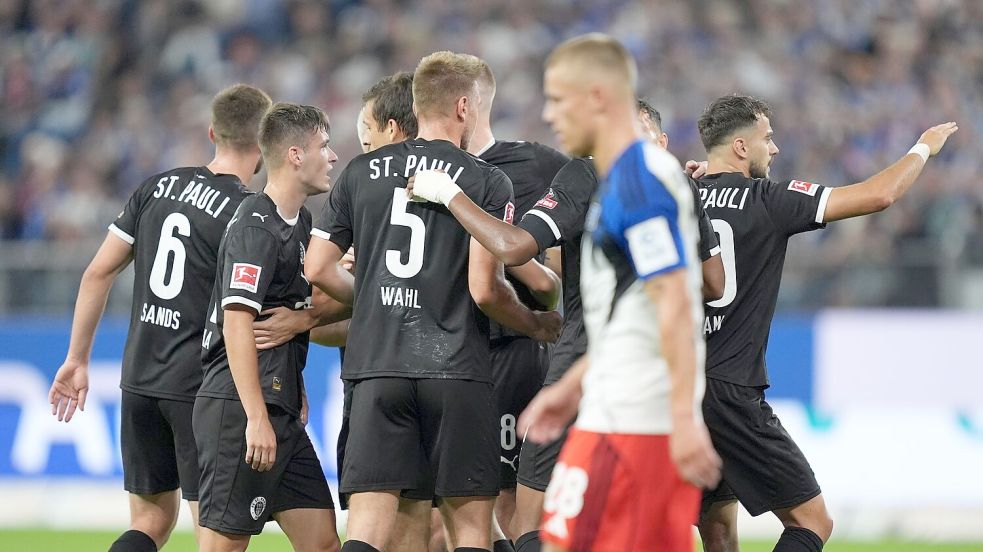 St. Paulis Spieler jubeln nach dem Treffer zum 0:1. Foto: Marcus Brandt/dpa