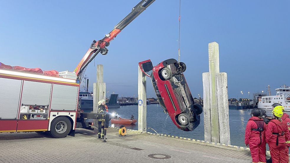 Mit einem Kran holten die freiwilligen Helfer den verunglückten Fiat aus dem Hafenbecken. Foto: Feuerwehr Norden
