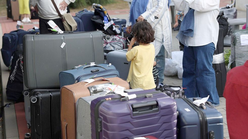Menschen aus Afghanistan, die zuvor mit einem Flugzeug am Flughafen Hannover gelandet sind, stehen im Grenzdurchgangslager Friedland an ihren Koffern. Foto: Stefan Rampfel/dpa
