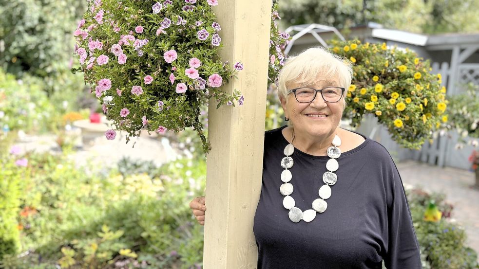 Henny Wrzos in ihrem Garten in Völlenerkönigsfehn. Sie erzählt von ihren Erinnerungen an das erste Wiesmoorer Blütenfest. Foto: Nicole Böning