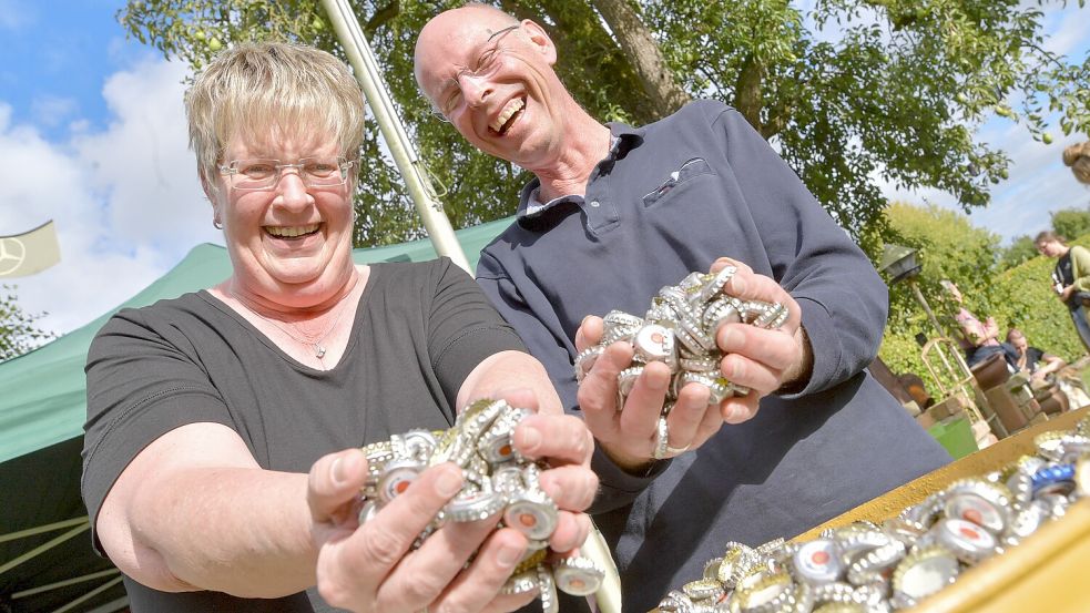 Susanne und Jürgen Frerichs aus Großefehn stehen vor den 55.000 Kronkorken aus Großoldendorf. Foto: Klaus Ortgies
