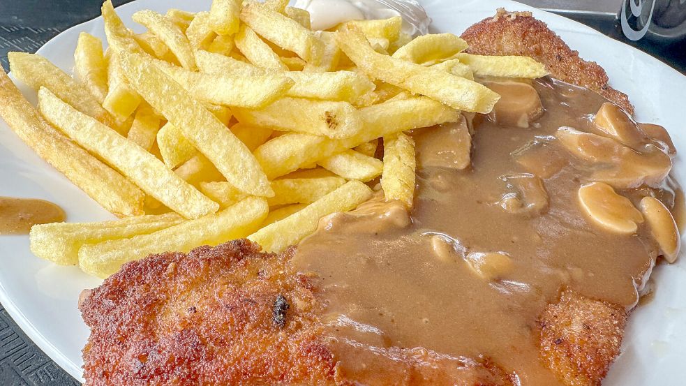 Zum Symbol für teures Essen geworden: paniertes Schweineschnitzel mit Sauce und Pommes Frites. Foto: IMAGO/Rüdiger Wölk