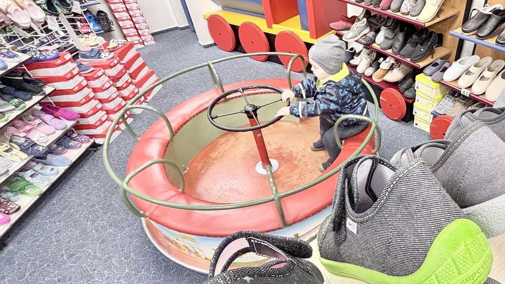 Seit dem Jahr 1962 ziert das Lurchi-Karussell die Kinderschuh-Abteilung im Schuhhaus Haltenhoff in Wiesmoor – hier fährt der zweijährige Linus aus Friedeburg. Foto: Klaus Ortgies