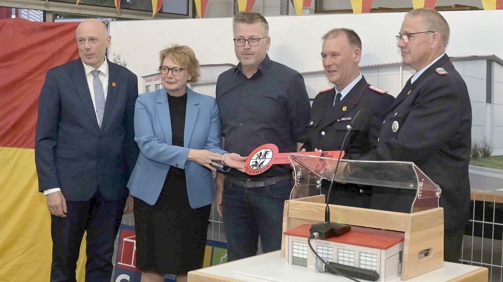 Bürgermeister Erwin Adams (von links), Daniela Behrens, Architekt Sven Bünting, Mario Lienemann und Ortsbrandmeister Roland Cremer bei der symbolischen Schlüsselübergabe. Foto: privat