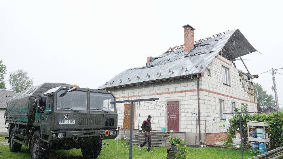 Ein Mann geht an einem beschädigten Haus vorbei, nachdem russische Drohnen den polnischen Luftraum verletzt haben. (Archivbild) Foto: Czarek Sokolowski/AP/dpa