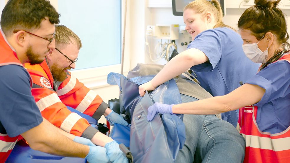 Teamarbeit: Mitarbeiter von Rettungsdienst und Klinik lagern gemeinsam eine Patientin um.Foto: Trägergesellschaft