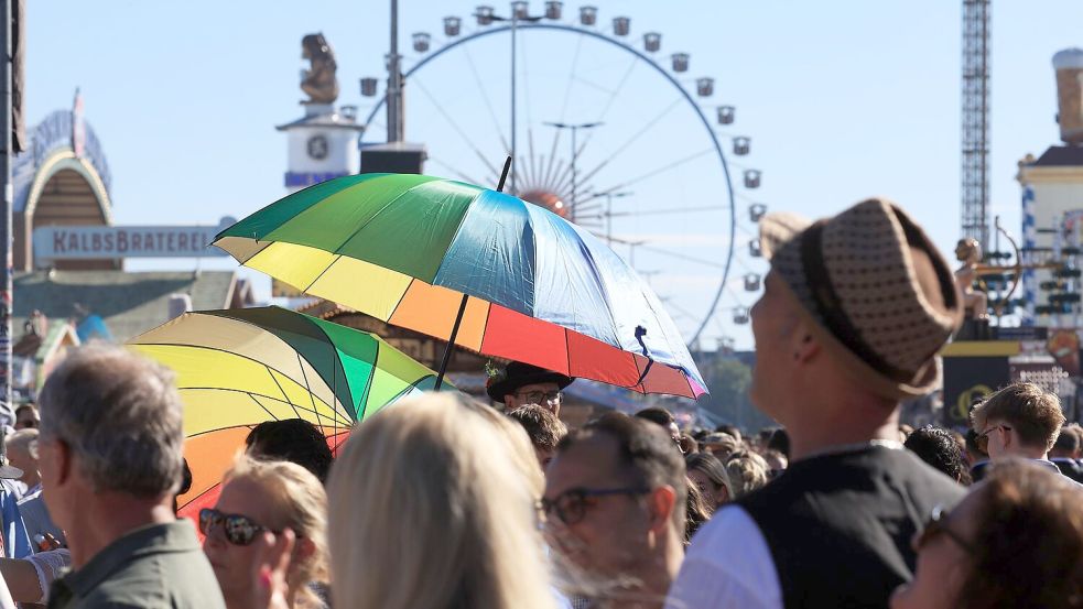 Hochsommerliche Temperaturen auf der Wiesn - da gewährten Schirme zumindest ein wenig Schatten. Foto: Karl-Josef Hildenbrand
