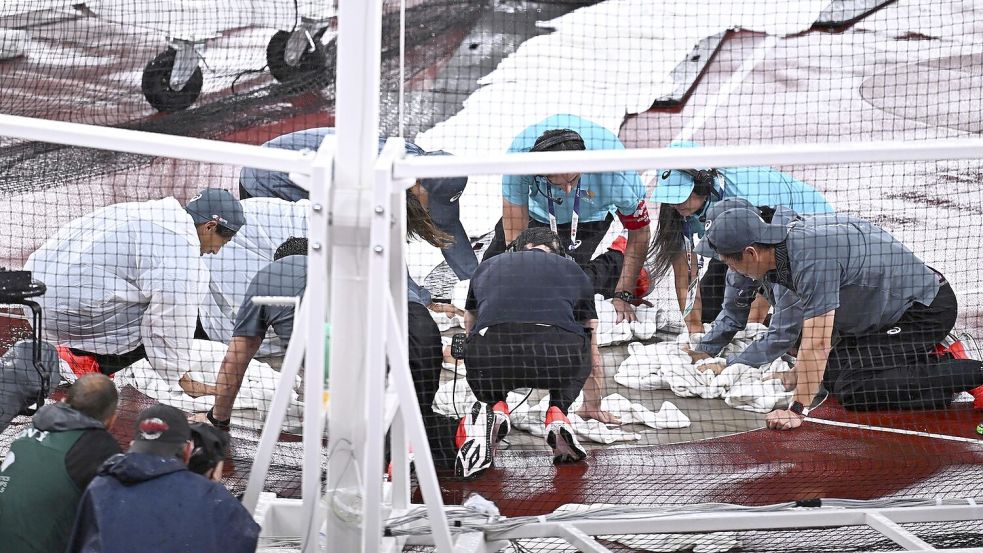 Vergeblich versuchten Helfer mit Handtüchern, den Wurfring trocken zu bekommen. Fotos: Imago