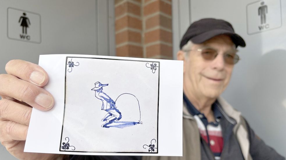 Die Tür zum WC am Markt ist zu. Im Scherz zeigt Dr. Egon Helling ein Foto von einer Delfter Fliese. „Das Motiv passt zur Situation“, findet er. Foto: Marion Janßen