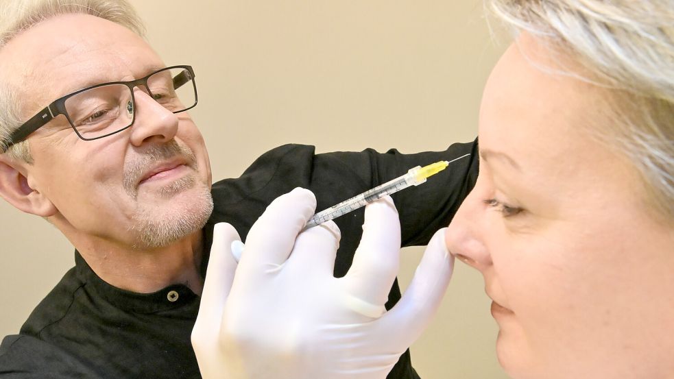 Mit ruhiger Hand führt Neurologe Arndt Grupe die Nadel an die Stirn seiner Mitarbeiterin Olesja Axt. Foto: Klaus Ortgies