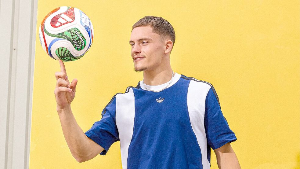 Florian Wirtz mit dem offiziellen WM-Spielball „Trionda“. Foto: ---/Adidas/dpa