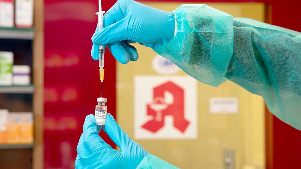 Eine Apothekerin steckt eine Spritze in den Impfstoff gegen das Coronavirus. Foto: Friso Gentsch/dpa