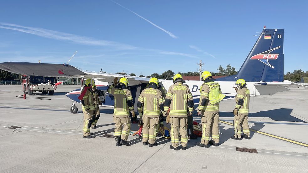 Mitarbeiter der Bundeswehr-Feuerwehr auf dem Wittmunder Militärflughafen umringen einen hier gelandeten Inselflieger der Reederei Frisia. Foto Reederei Frisia