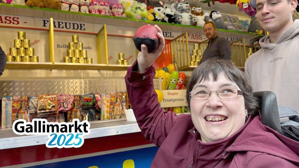 Gerlinde Flessner probiert sich am Dosenwerfen auf dem Gallimarkt. Hinter ihr ist Soldat David Fries, der sie über den Gallimarkt begleitet. Foto: Lars Löschen