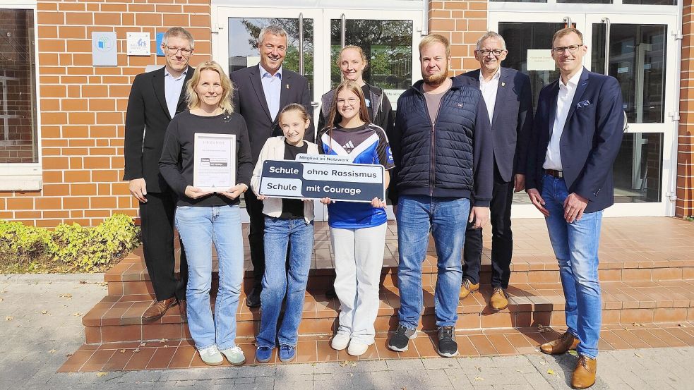 Jenko Gerdes (didaktischer Leiter, von links), Lehrerin Kristin Jacobs, Johann Saathoff, die Schülerinnen Lira Arends und Emma Brink, die Koordinatoren Sophie Eickhorst und Malte Frederichs, Landrat Olaf Meinen und der stellvertretende Schulleiter Dr. Markus Rohmann freuen sich über die Urkunde. Foto: privat