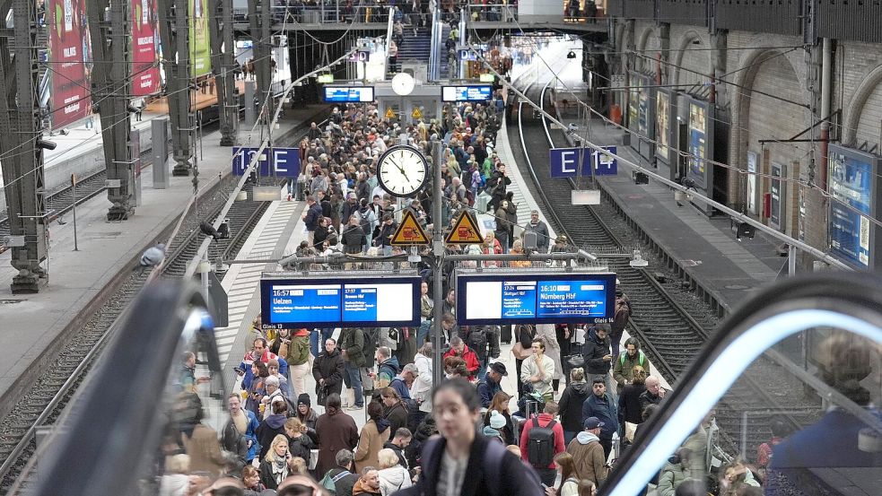 Fahrgäste warten am Bahnsteig auf ihren Zug im Hauptbahnhof Hamburg: Wegen eines Kabelschadens ist der Zugverkehr stark beeinträchtigt. Foto: dpa/Marcus Brandt