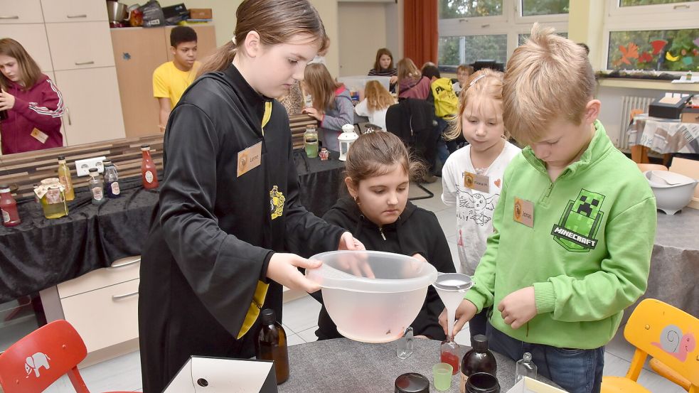 Mit vereinten Kräften füllen diese Kinder einen selbstgemixten „Lachtrunk“ in Fläschen. Fotos: Thomas Dirks