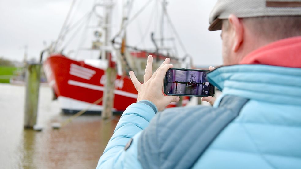 Spaziergänger treibt es zum überfluteten Hafen von Greetsiel. Foto: Heinz Wagenaar