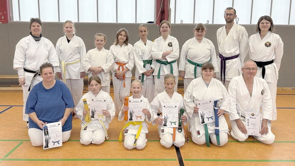 Die erfolgreichen Prüflinge Angelika Kleen (vordere Reihe, von links), Fiona Rohlfs, Wiebke Janssen, Maya Kleen, Christin Kleen und Johann Heddinger präsentieren nach bestandener Prüfung ihre Gürtel und Urkunden. Mit auf dem Foto sind die Mitglieder der Karateka-Gruppe im Osteeler Turnverein, die sie unterstützt haben. Foto: privat