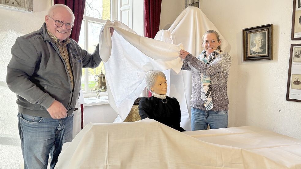 Menno Müller und seine Tochter Imke Müller versetzen die Manningaburg in den Winterschlaf und schützen die Ausstellungsstücke – in diesem Fall ein Modell von Deutschlands erster Frauenärztin Hermine Heusler-Edenhuizen – vor Staub und Feuchtigkeit. Foto: Hannah Weiden