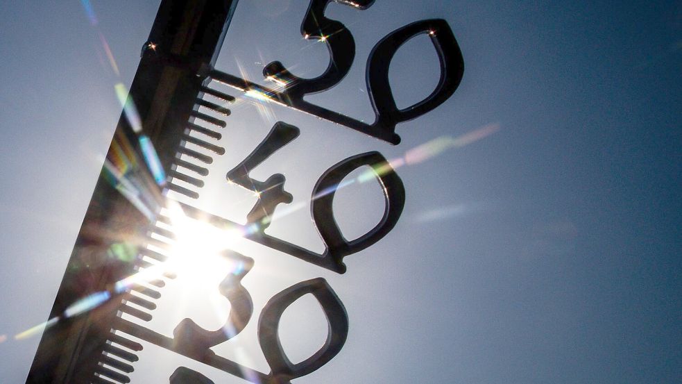 Vor einem wolkenlosen blauen Himmel zeigt ein Außenthermometer in einem Garten bereits am Vormittag über 30 Grad Lufttemperatur an. (Illustration) Foto: Jens Büttner