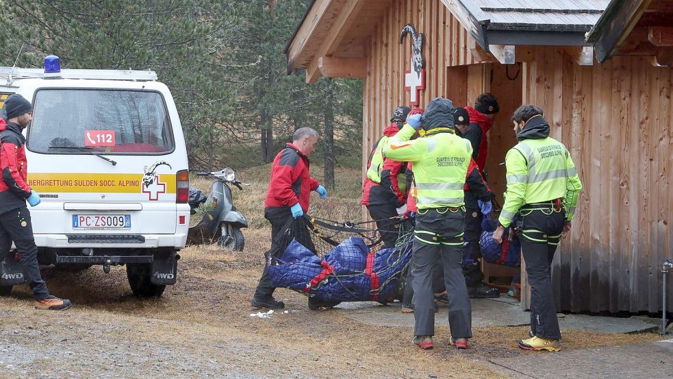 Zwei der Todesopfer werden zu einer Hütte getragen. Foto: Karl-Josef Hildenbrand