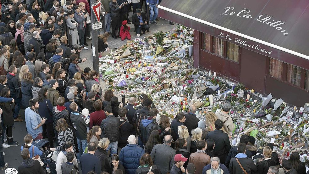 Menschen versammeln sich am 15. November 2015 vor einem provisorischen Mahnmal am Restaurant „Le Carillon“ in Paris – einem der Tatorte der Anschläge. Foto: AFP/ALAIN JOCARD