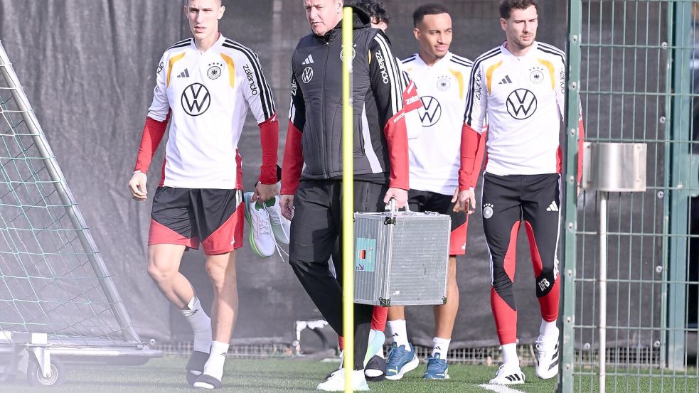 Mit Teamarzt Hahne (2.v.l.) betritt Schlotterbeck (l.) den Trainingsplatz. Foto: David Inderlied