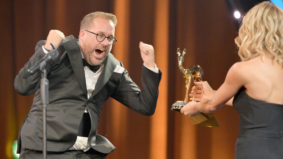 Mit Freudensprüngen auf die Bühne. Paul Ronzheimer freut sich sichtlich über den Bambi für seinen Politik-Podcast. Foto: Peter Kneffel/dpa