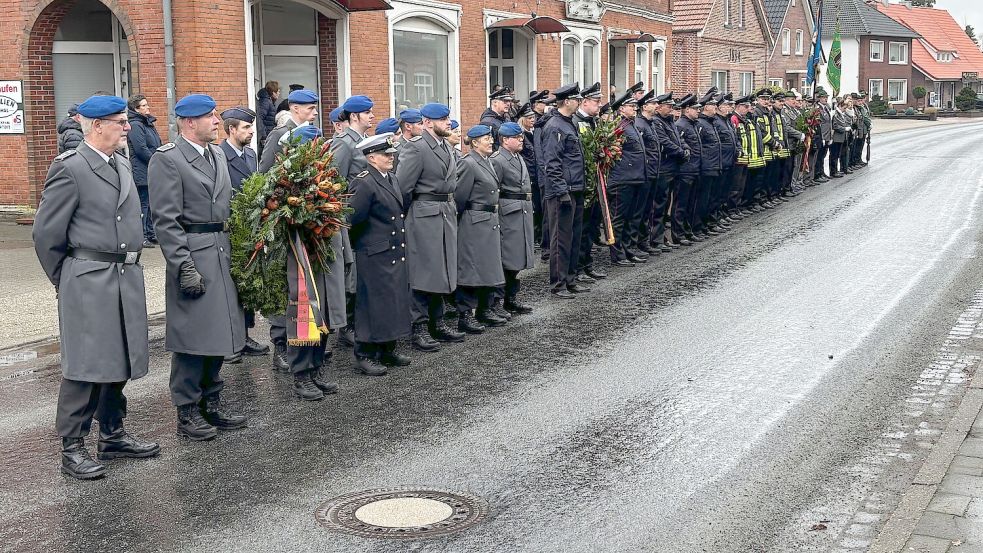 Kurz nachdem dieses Bild entstand, mussten die Teilnehmer der Ehrenformation weiter zurückgehen, weil zwei Polizeifahrzeuge mit Blaulicht und Martinshorn dort langfahren mussten. Die Polizisten waren auf dem Weg zu einem Einsatz bei der neuen Friesenbrücke bei Hilkenborg. Foto: Carsten Ammermann